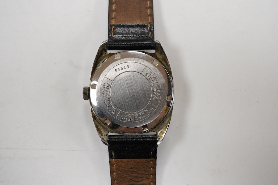 A gentleman's stainless steel manual wind wrist watch, retailed by Garrard, with baton numerals, case diameter 33mm, on a black leather strap.